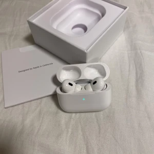 Apple AirPods Pro 2 med laddningsetui - Säljer ett par vita Apple AirPods Pro som jag knappt använder längre. Snygg och kompakt design i blank plast, perfekt för dig som vill ha grymt ljud och brusreducering. Levereras med originalkartong, laddkabel och extra öronproppar.