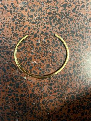 Guld armband från muli - Snyggt och minimalistiskt armring i 18k guld från Muli. Armbandet har en öppen design och är stilrent utan extra dekorationer, vilket gör det lätt att matcha med andra smycken. Perfekt för dig som gillar enkel och modern stil.