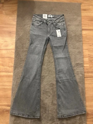 Lager 157 grå bootcut jeans - Snygga grå Lager 157 jeans med klassisk bootcut passform. Tillverkade i mjuk bomullsdenim som ger en skön känsla och cool look. Perfekta för dig som gillar retrovibbar och vill sticka ut.