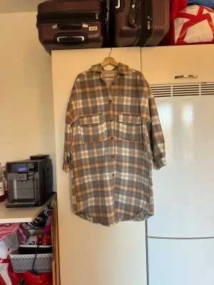 Rutig overshirt från Cream, L - Säljer en oversized rutig overshirt från Cream i storlek L. Jackan har bruna, gråa och beige toner, stora bröstfickor och knappar hela vägen. Perfekt för lager-på-lager och chill stil. Materialet är mjukt och känns som ullblandning. Mycket fint skick, jag hittar inga synliga anmärkningar eller defekter. 