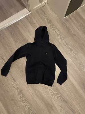 Lyle and Scott hoodie  - Mörkblå/Svart Lyle and Scott hoodie med den klassiska fågel loggan på bröstet. Tröjan är i storlek S och är i ett bra skick. 