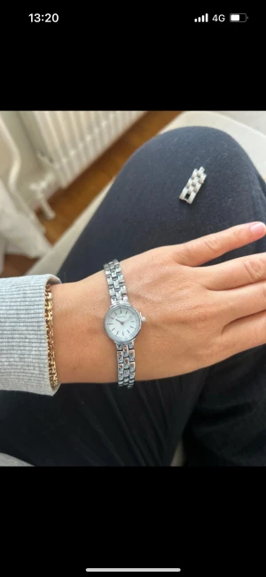 Bouvo blocka ny - Bilderna visar en silverfärgad klocka från Bovou med länkarmband, men ingen väst syns på bilderna.