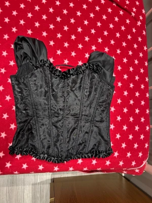 Svart korsett med puffärmar - Säljer denna korsetten med puffarmar i stl L, jätte fin och väldigt hållbart material och perfekt för kosymer eller fester
