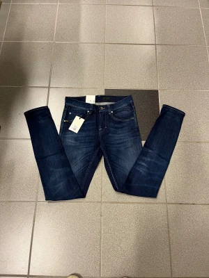 Mörkblå slimmade Tiger of sweden jeans  W29 L32 - Säljer ett par mörkblå slimmade jeans för herr med tighta ben och smal fot. Klassisk femficksmodell med snygga slitningar och kontrastsömmar. Perfekta för dig som gillar en smal siluett och vill ha ett par stilrena jeans i garderoben.