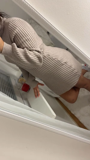 Beige ribbad stickad kortklänning - Supermysig beige stickad klänning med ribbat mönster och polokrage. Modellen är kort och har långa ärmar med en relaxed fit. Perfekt för dig som gillar en chill och snygg stil under kyligare dagar.