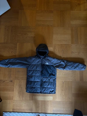 Grå o svart The North Face dunjacka  - Grå o svart the north face dunjacka som går att vända ut och in så den blir hel svart den är storlek xs 