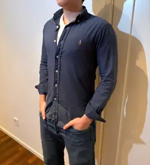 En mörkblå Ralph Lauren skjorta i storlek Small Slim fit, mycket fint skick. Otroligt stilren och skön passform. Hör av er vid frågor.