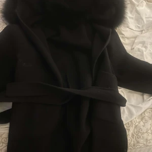 Svart kappa med päls och bälte - Svart kappah från furstockholm använd ett par gånger.