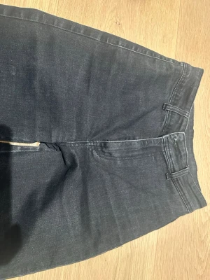 Svarta jeans från SHEIN, storlek S - Svarta cargopants från SHEIN med raka ben och stora fyrkantiga fickor bak. Byxorna har dragkedja och knapp framtill samt hällor för bälte. Materialet är jeansliknande och ger en cool vibe. Perfekt för dig som gillar streetstyle och funktionella detaljer.