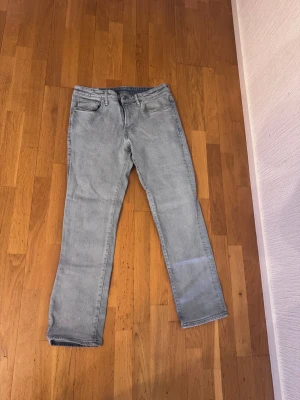 Ljusgrå straight fit jeans - Storlek 32/32 Snygga ljusgrå jeans med straight regular fit. Klassisk femficksdesign och dragkedja i gylfen. Jeansen har en enkel look som funkar till många stilar och är tillverkade i mjukt denimtyg för skön känsla hela dagen. Knappt använda 