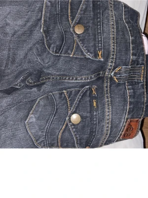 Low waisted jeans - Snygga mörkblå jeans från Lee med coola kontrastsömmar och unika fickdetaljer. Modellen har låg midja och raka ben, med Lee-logga på knapp och läderpatch bak. Jeansen är tillverkade i klassiskt denim och har en casual vibe.