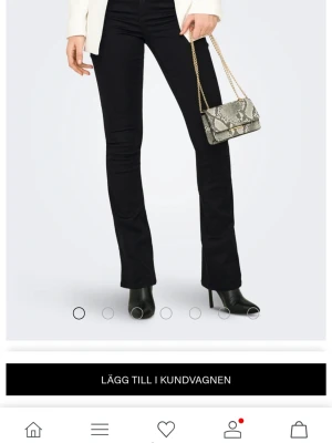 Svarta bootcut jeans från ONLY - Snygga svarta jeans från ONLY blush med bootcut-snitt och hög midja. Modellen har klassiska fem fickor, bälteshällor och är tillverkad i stretchig bomullsmix för en bekväm passform. Perfekt för dig som gillar en tidlös och trendig look. XL/34