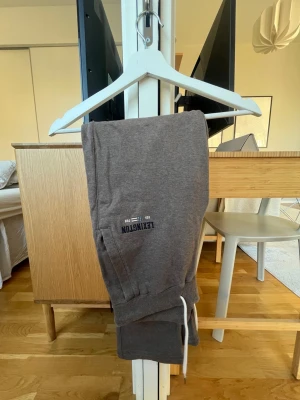 Bruna mjukisbyxor från Lexington S - Säljer ett par bruna mjukisbyxor från Lexington i storlek S. Byxorna har vita snören i midjan, ribbade muddar och två sidofickor. Materialet är mjukt bomullstyg och tryckt Lexington-logga på ena benet. Perfekt för chill dagar hemma.