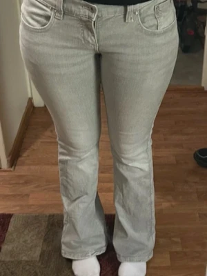 Ljusgrå bootcut jeans - Snygga ljusgrå jeans med klassisk bootcut-passform. Jeansen har fem fickor, bälteshällor och dragkedja med knapp framtill. Materialet är jeans och färgen är en fräsch ljusgrå ton som passar till många olika stilar.