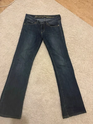 Mörkblå bootcut low waist jeans från Guess - Snygga mörkblå jeans från Guess med klassisk bootcut-passform och broderad logga på insidan av linningen. I storlek 26/25, passar perfekt för någon som är runt 155/160 cm! Valde tyvärr att sälja eftersom jag inte haft någon användning för dem. PRISET KAN DISKUTERAS 