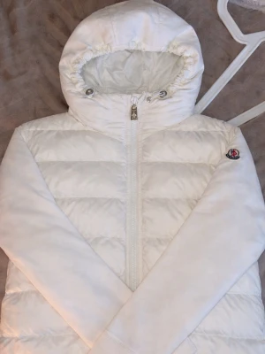 Cardigan från Moncler dam  - Säljer en vit cardigan/pufferjacka från Moncler. Mycket bra skick och sparsamt använd, en av mina favorit jackor men måste tyvärr sälja av grejer och tjäna pengar. Qr kod! finns i jackan vid  snabb smidig affär kan priset sänkas!🎀 
