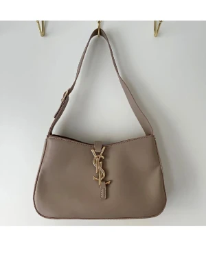 Beige axelväska  - Säljer en snygg beige axelväska emblem framtill. Väskan har en stilren och mjuk form, justerbar axelrem. Perfekt för dig som gillar klassisk design med lyxig touch.