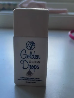 Golden tan drops  - Golden Glow Drops från W7 är flytande bronzerdroppar i en smidig plastflaska med skruvkork. Ger en varm, gyllene ton och glow till huden. Perfekt att blanda i foundation eller använda direkt på huden för en solkysst look. Vegansk och lätt att applicera. Mycket kvar! 