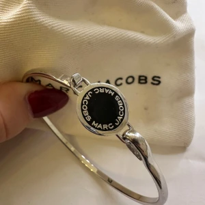 Armband från Marcc Jacobs   - Jättesnyggt och lyxigt armband från Marc Jacobs. Den är silvrig och har svarta detaljer. Använd ett fåtal gånger men visar inga tecken på skador. 