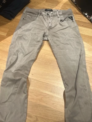 Replay Hyperflex Anbass grå jeans - Säljer ett par Replay Hyperflex Anbass jeans i grått med klassisk femficksdesign och snygga detaljer som Replay-logga på fickan och läderpatch bak. Stretchigt material för extra komfort och smal passform som sitter snyggt hela dagen.