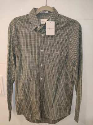 Grön rutig skjorta från GANT - Grön, rutig skjorta från Gant i storlek S. Prislapp sitter fortfarande kvar, aldrig använt..