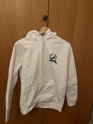 Vit hoodie med tryck från Sjöstjärnans Ridläger - Vit hoodie med tryck på vänster bröst och på ryggen. Lätt fleece i och strl M.