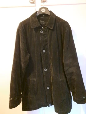 Rappson svart jacka, storlek 56/58 - Säljer en svart jacka i manchester från Rappson. Jackan har klassisk krage, stora knappar framtill och två fickor. Långärmad och loose fit, perfekt för lager på lager. Enkel och stilren design som funkar till det mesta. Hsr även manschetter med knappar. Storlek 56/58. Är i bra skick som ny & sparsamt använd.   Skickas via posten men köpare står för frakten. Vid övriga frågor skicka gärna meddelande.  Lämnar självklart god omdömen om köpare gör det!