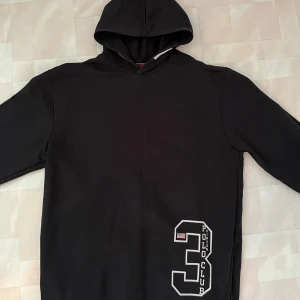 Svart hoodie från Vinson Polo Club - Svart hoodie från Vinson Polo Club. Stor vit siffra 3 och amerikansk flagga tryckt på framsidan nedtill. Klassisk huva och långa ärmar. Frakt tillkommer! 🔴OBS STORLEK BARN 170!🔴