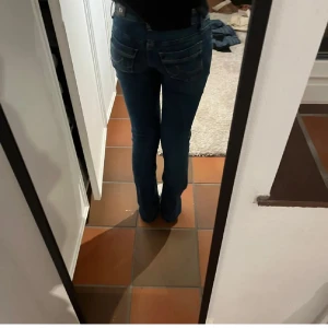 Blå bootcut jeans från LTB - Snygga blå jeans från LTB i modellen Valerie. Jeansen har klassisk femficksdesign, kontrastsömmar och bootcut-ben. Tillverkade i mjukt denimtyg som sitter skönt och har en tidlös look. Perfekta för dig som gillar en avslappnad men ändå trendig stil. Lite insydda i midjan skriv för en bild ! Super fina