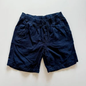 Mörkblå bomullsshorts med resår - Snygga mörkblå shorts i mjuk bomull med elastisk midja och två sidofickor. Perfekta för varma dagar och enkel att matcha med t-shirt eller hoodie. Klassisk och avslappnad stil som funkar till det mesta.