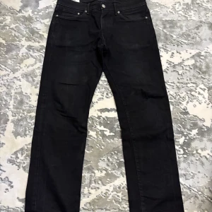 Svarta straight jeans från H&M - Svarta jeans från H&M i straight regular fit-modell. Klassisk femficksdesign med raka ben och normal passform. Jeansen är tillverkade i ett mjukt bomullstyg med lite stretch för extra komfort. Perfekta för en clean och stilren look.