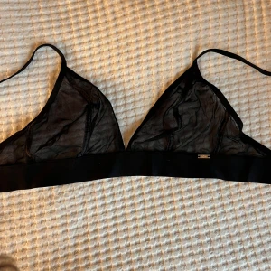 Svart bh  - Säljer en svart bh som är transparent. Behån har bred resår under bysten och justerbar knäppning bak. Jättesnygg aldrig använd