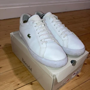 Vita Lacoste skor - Stilrena Lacoste skor som passar till allt, Säljer pågrund av ingen användning. Skorna är inte mycket använda så har mycket kvar att ge.  • Model: Powercourt • Storlek 43  • Mått 29 cm  Bara höra av dig du undrar något