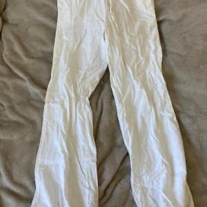 Vita linnebyxor från BikBok XS - Snygga vita linnebyxor från BikBok i storlek XS. Byxorna har rak passform, resår i midjan och knytband för extra komfort. Perfekta för varma dagar och ger en avslappnad vibe. Lätta och luftiga i materialet linne.