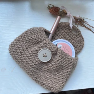 Virkad pouch - Ljusbrun virkad pouch. Perfekt att ha AirPods, smink eller kort i. Garnet är lite mörkare än på bild. (Innehållet på första bilden medföljer ej)💕
