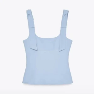 Ljusblå Zara topp - Supersöt ljusblå linnetopp med breda axelband som pryds av dekorativa rosettband. Toppen har en rak, något croppad passform och fyrkantig ringning. Perfekt för att skapa en fräsch och trendig look. Pris går att diskutera och om ni vill ha fler bilder så skriv bara!💞💞