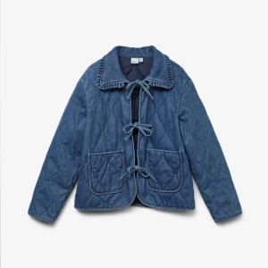 Quiltad jeansjacka med knytning - Säljer en supersöt blå quiltad jeansjacka som aldrig använts med tre dekorativa knyt framtill och två stora fickor. Den är i storlek L men väldigt liten i storleken så skulle säga att den passar S/M. Jackan har en bred krage med volangdetalj och lång ärm. Perfekt för dig som vill ha en unik och trendig vår- eller höstjacka i garderoben. Helt slutsåld på hemsidan, nypris 700kr. Skriv för fler bilder eller om du har några frågor!☺️💕