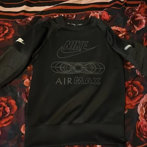 Svart Nike Air Max sweatshirt XS - Svart långärmad sweatshirt från Nike Air Max med tryck på bröstet och Air Max-detalj på ärmen. Tröjan har en clean look med rund hals och är tillverkad i ett mjukt, syntetiskt material. Perfekt för dig som gillar sportig och stilren streetwear.