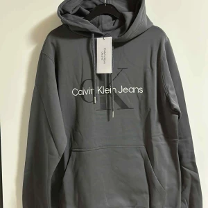 Grå hoodie från Calvin Klein Jeans - Snygg grå hoodie från Calvin Klein Jeans. Storlek M.          Ord 1299 kr  mitt 1099 kr 