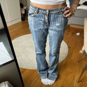 Blå jeans med kontrastsömmar från Hope Star - Unika blå jeans från Hope Star med tydlig blekt effekt och vertikala ränder. Snygga kontrastsömmar i orange och klassisk femficksmodell. Låg midja och  ger en avslappnad vibe. Perfekta för dig som vill sticka ut med coola detaljer.
