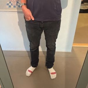Acne Studios Blå Konst mörkblå/svarta jeans - Snygga svarta jeans från Acne Studios Blå Konst med klassisk femficksdesign och diskreta slitningar. Jeansen är i strl 33 och i fint skick, jeansen är lagade i grenen👍