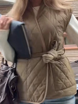 Quiltad beige väst med bälte från Neo Noir - Säljer en så snygg olivgrön quiltad väst från Neo Noir med korta ärmar och knytskärp i midjan. Västen har ett snyggt rutmönster och är gjord i ett mjukt, vadderat material. Den har två fickor framtill. Den är i mycket bra skick och har inga tecken på användning. Passar jättefint på storlek S. 