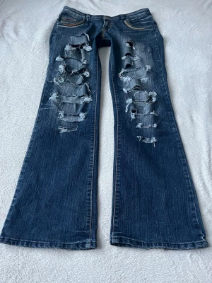 Coola jeans med slitningar  - Storlek L men sitter som M på mig. Innerbensländen är 82cm, midjemåttet 41cm och  grenhöjden 19cm. Inga större defekter bara lite slitna längst nere, för fler bilder/frågor skriv💕