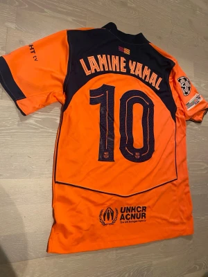 HELT NY Rosa-Orange Barcelona 25/26 T-shirt  - •Hej! Säljer en jätte snygg Rosa-orange Barcelona 25/26 fotbolls T-shirt med Lamine Yamal på ryggen ⚽️👕 Den är lite mer rosa än vad det ser ut på bilden. •Den är inte använd bara testad.  •Det är storlek M och den har inga hål eller liknande. •Måtten är på dem sista bilderna 📐.  •Priset kan diskuteras och skickar inom 24 Tim😊💨