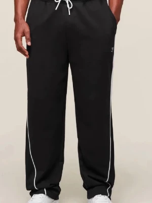 Svarta mjukisbyxor gymshark - Säljer ett par svarta mjukisbyxor med vita kontrastsömmar längs benen och dragsko i midjan. Byxorna har avslappnad passform och resår i bensluten. Perfekta för chill dagar eller träning. Liten logga på låret.