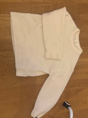 Vit stickad tröja 🤍 - Klassisk vit stickad tröja  med rund halsringning och ribbade muddar vid ärmslut och nederkant. Tröjan har en rak passform och är perfekt för lager-på-lager-stil. Materialet ser mjukt och mysigt ut.