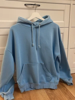 Ljusblå bikbok hoodie - En ljusblå hoodie med huva och dragsko, samt en stor känguruficka framtill. Knappt använd💕