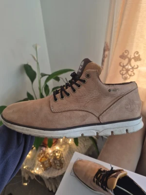 Timberland Bradstreet Chukka leather boots with Gore-Tex Brun EUR 43.5 passar 42 - Snygga beige kängor från Timberland med svart snörning och vit sula. Skorna är tillverkade i skinn och har en klassisk rund tå. Perfekta för dig som gillar en stilren och avslappnad look.
