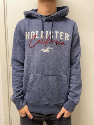 Hollister hoodie - Snygg mörkblå hoodie från Hollister. Väldigt bra skick. Modellen är 173cm, 64kg. Pris kan diskuteras!
