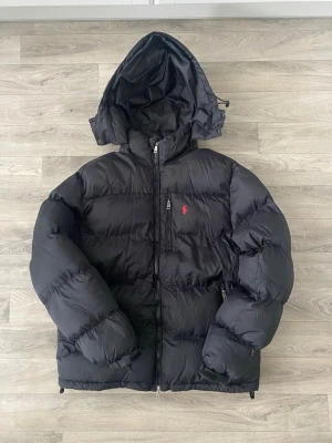 Ralph Lauren puffer jacket  - Säljer denna puffer jacket från Ralph lauren i färgen marinblå storlek M. Väldigt skön och varm nu vid kallare dagar. Bra skick däremot blev den smutsig ett tag och hamnade i tvätten. Detta gjorde att materialet på jackan blev lite stramare men inget som märks när man har på sig den därav det lägre priset. 